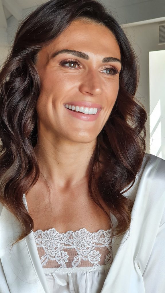 Beautiful bride Gorana smiling in a wedding portrait at Martinis Marchi on the island of Šolta, wearing natural bridal makeup by Katarina Ramic.