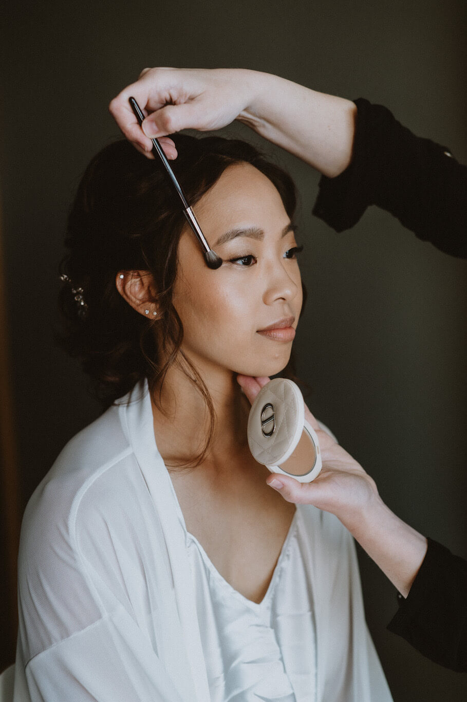 Beautiful Asian bride in Dubrovnik having final makeup touches applied with Dior bronzer by makeup artist Katarina Ramic.