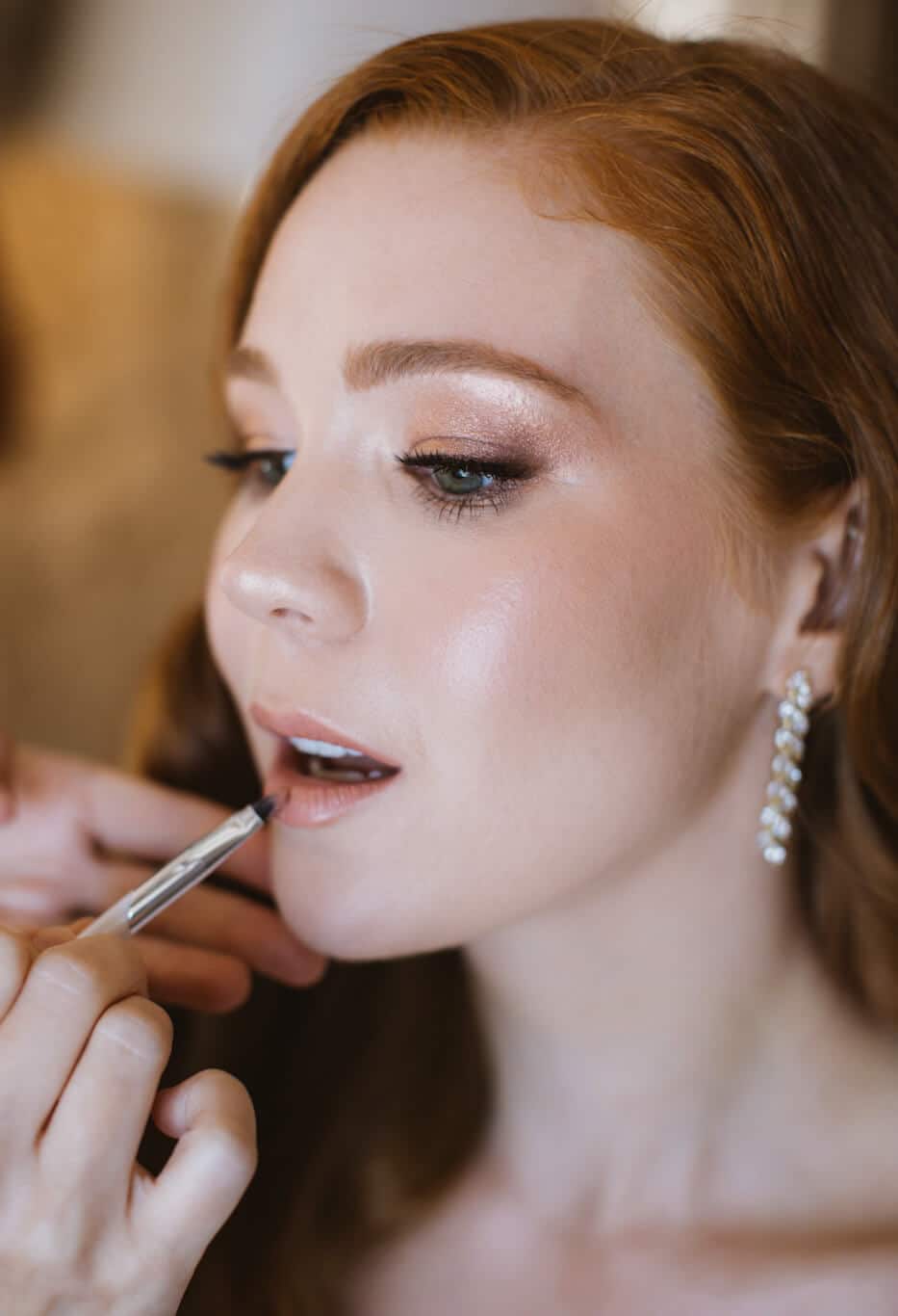Close-up of bride in Hvar, Croatia with seamless makeup as Katarina “Kate” Ramic applies lipstick with a brush.