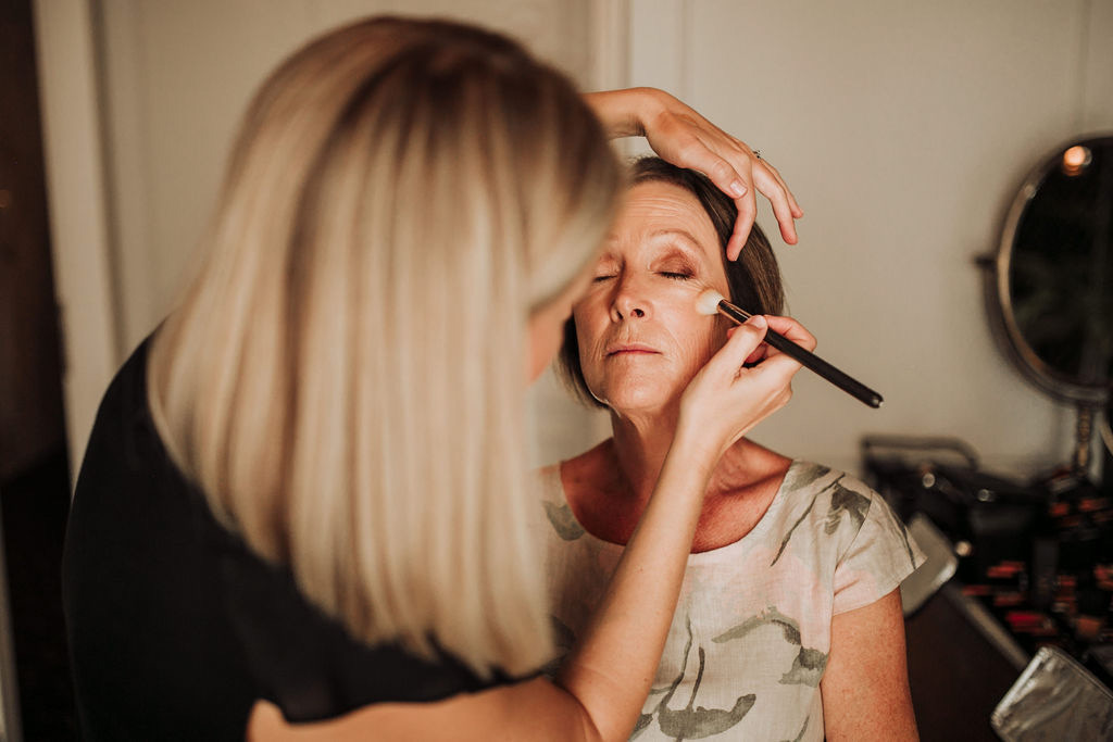 Mother of the bride having makeup applied in Trogir, Croatia by Katarina Ramic, eyes closed and relaxed during wedding preparation.