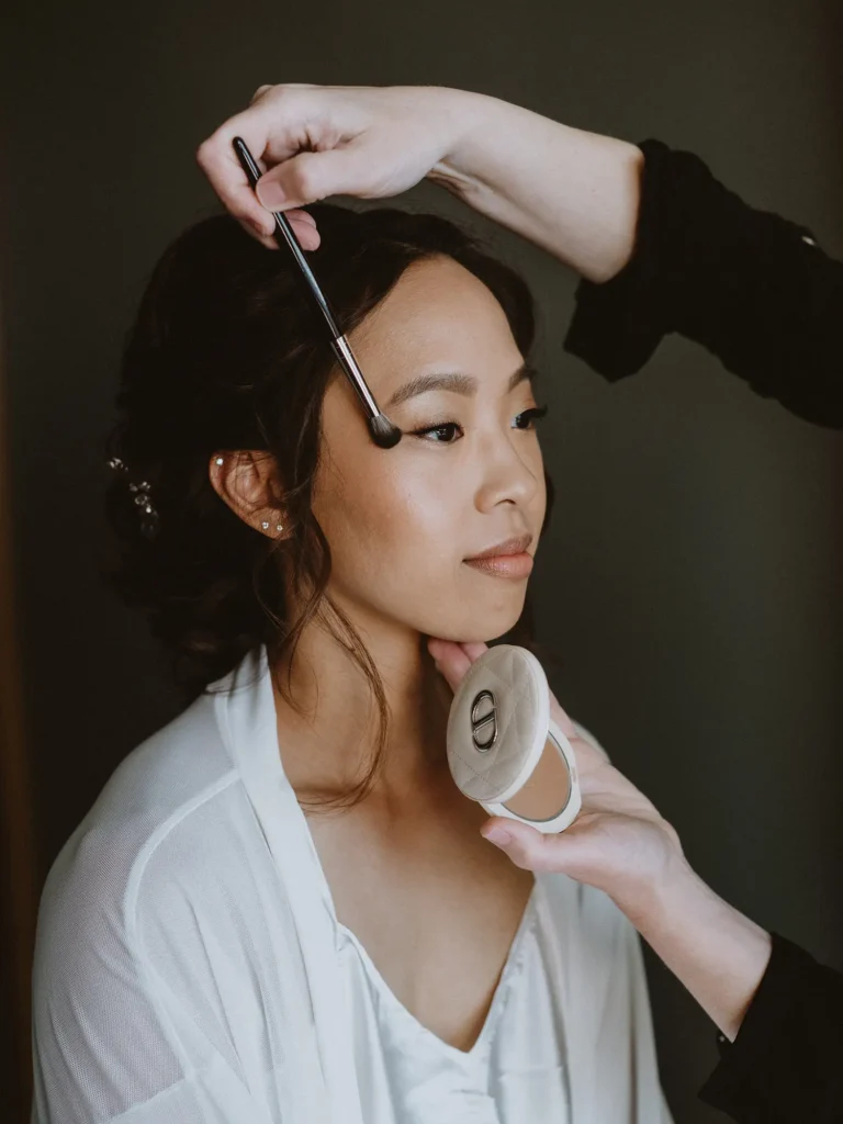 Beautiful Asian bride in Dubrovnik having final makeup touches applied with Dior bronzer by makeup artist Katarina Ramic.
